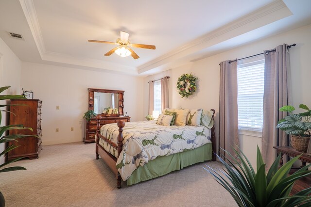 bedroom featuring ceiling fan, a tray ceiling, and light colored carpet