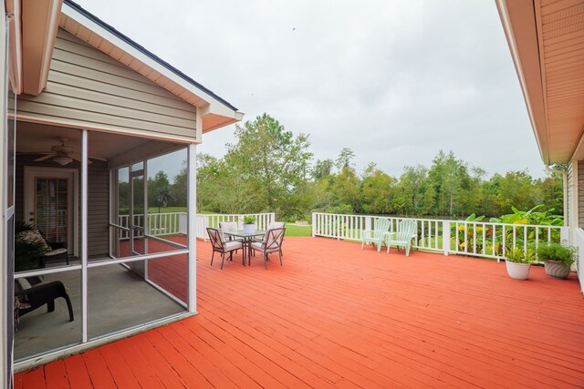 wooden deck featuring ceiling fan and a sunroom