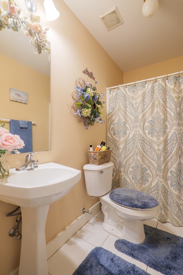 bathroom featuring toilet, tile patterned flooring, and sink