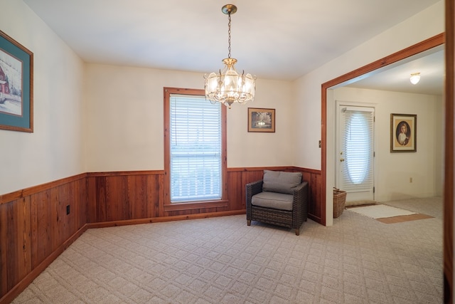 sitting room featuring an inviting chandelier and light carpet