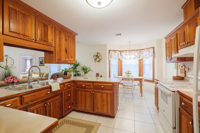 kitchen with kitchen peninsula, white range with electric stovetop, light tile patterned floors, sink, and decorative light fixtures