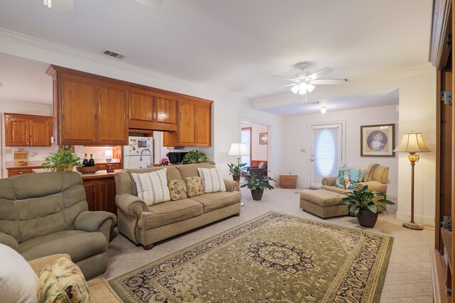 living room with ceiling fan, light colored carpet, and crown molding