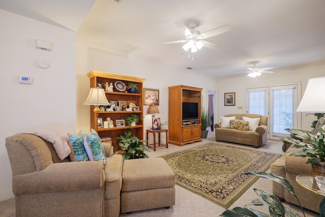 living room with ceiling fan, ornamental molding, and carpet