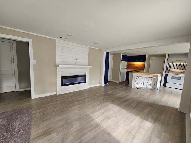 2105 N Troup St, Valdosta, GA 31602 - unfurnished living room with a glass covered fireplace, dark wood-style flooring, and crown molding