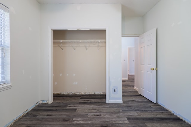 unfurnished bedroom featuring a closet and dark hardwood / wood-style floors