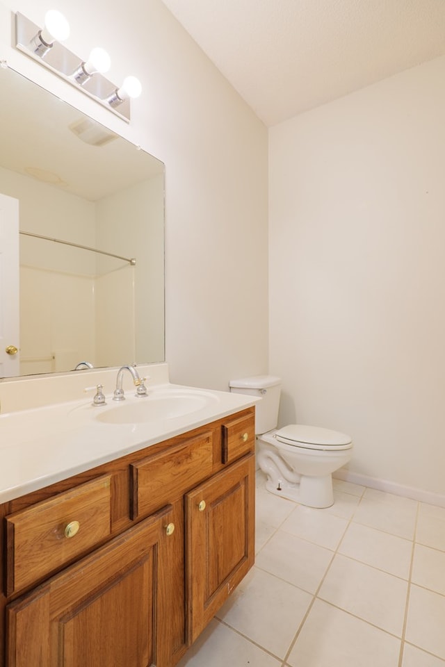 bathroom featuring tile patterned flooring, vanity, a shower, and toilet