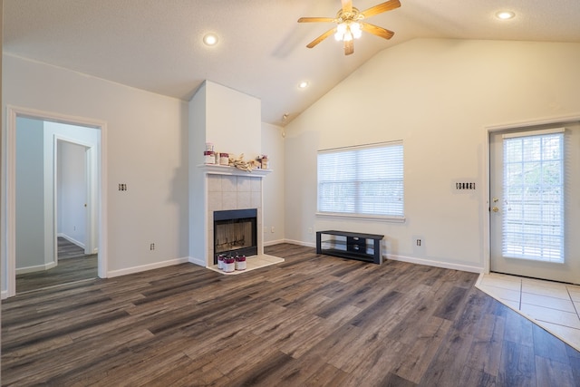 unfurnished living room with dark hardwood / wood-style flooring, vaulted ceiling, plenty of natural light, and a fireplace