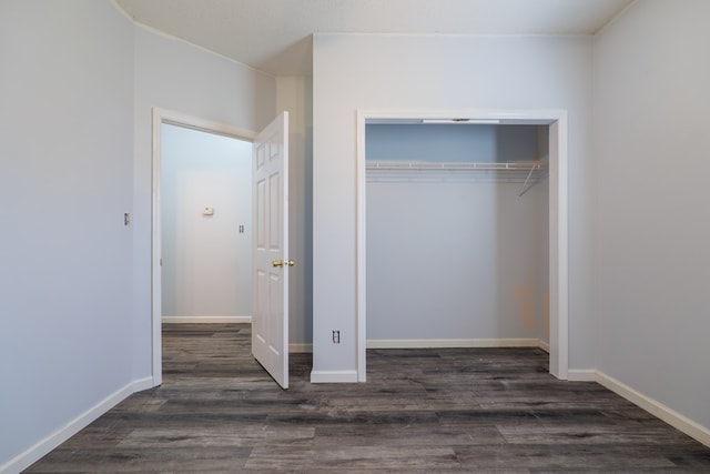 unfurnished bedroom with dark hardwood / wood-style flooring and a closet