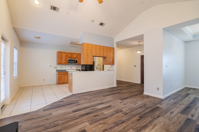 kitchen with white range with electric cooktop, lofted ceiling, sink, ceiling fan, and light hardwood / wood-style floors