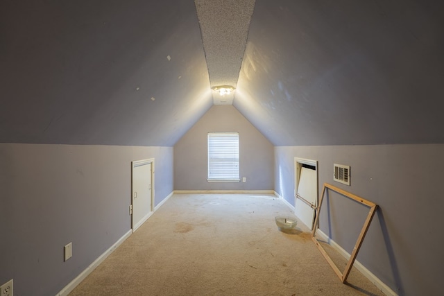 additional living space with vaulted ceiling and light carpet