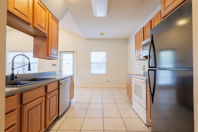 kitchen featuring sink, light tile patterned flooring, a textured ceiling, and appliances with stainless steel finishes