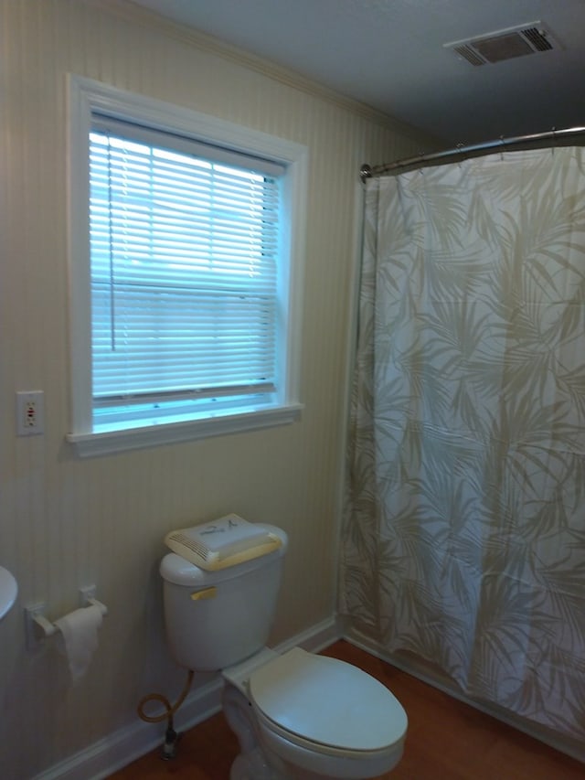 bathroom with curtained shower, hardwood / wood-style flooring, and toilet