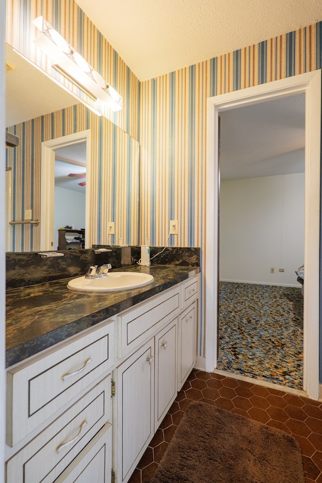 bathroom with vanity, wallpapered walls, and tile patterned flooring