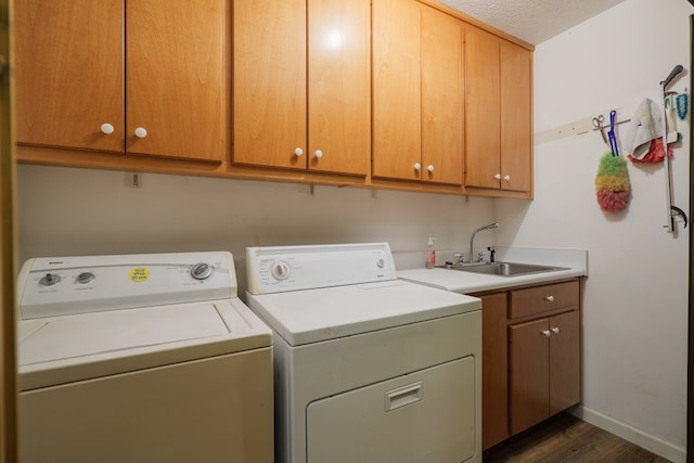 laundry room with a sink, cabinet space, independent washer and dryer, dark wood-style floors, and baseboards
