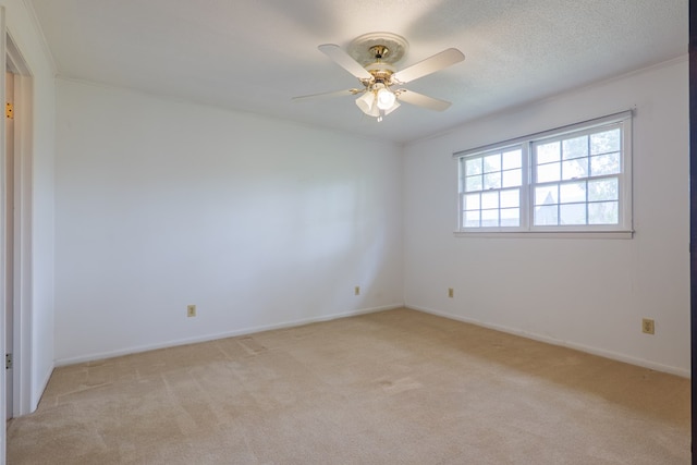 spare room featuring light colored carpet, baseboards, and a ceiling fan