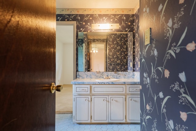 bathroom with tile patterned floors, wallpapered walls, and vanity
