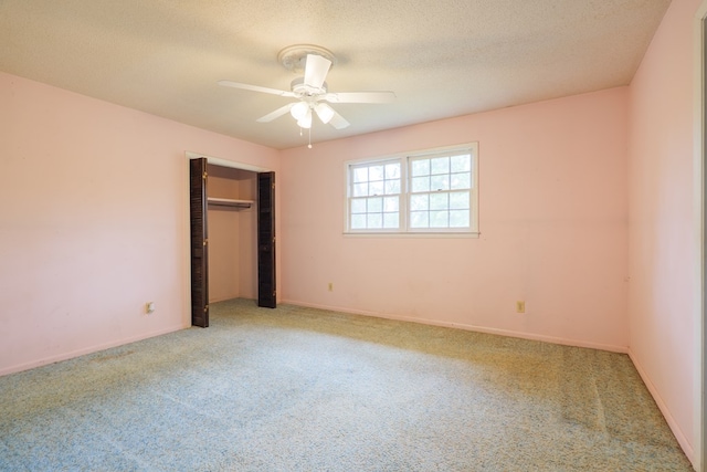 unfurnished bedroom featuring baseboards, a textured ceiling, a closet, and carpet