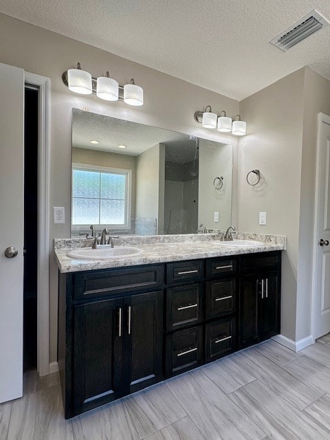 bathroom featuring a textured ceiling and vanity