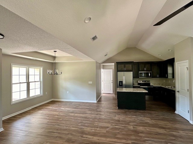 kitchen featuring a center island, dark hardwood / wood-style floors, pendant lighting, a chandelier, and appliances with stainless steel finishes