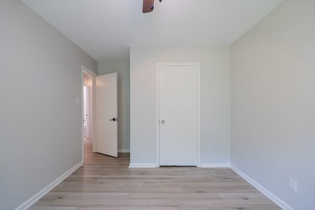 unfurnished bedroom featuring baseboards, ceiling fan, and light wood-style flooring