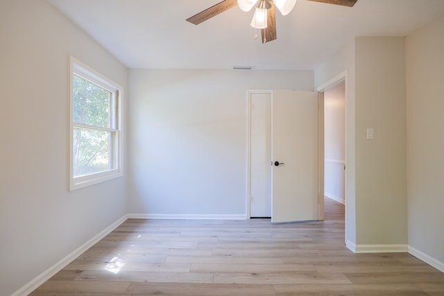 empty room with visible vents, light wood-style flooring, ceiling fan, and baseboards