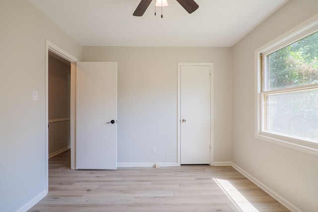 unfurnished bedroom featuring baseboards, a ceiling fan, and light wood-style flooring