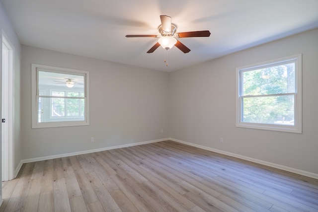 spare room with baseboards, ceiling fan, and light wood finished floors