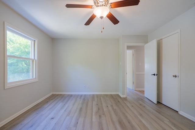 unfurnished bedroom featuring a ceiling fan, baseboards, and light wood-style flooring