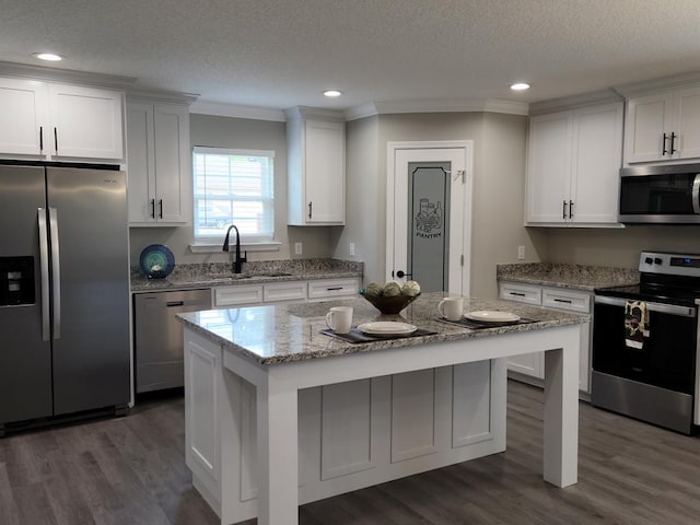 kitchen featuring white cabinets, sink, a kitchen island, and stainless steel appliances