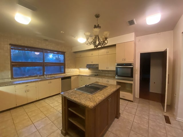 kitchen with a center island, sink, light tile patterned floors, a notable chandelier, and stainless steel appliances