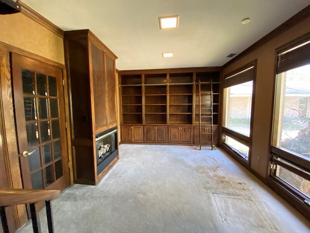 unfurnished living room featuring light colored carpet and ornamental molding