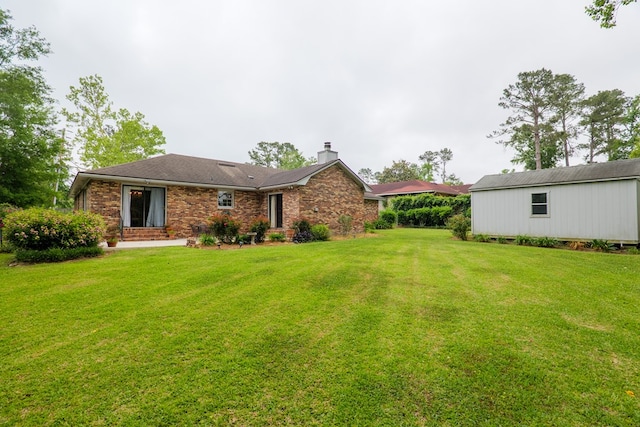 303 Breckenridge Dr, Valdosta, GA 31605 - back of property featuring a chimney, a lawn, and brick siding