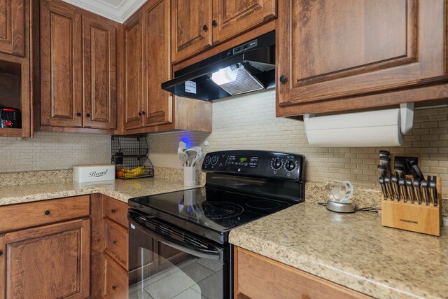 3417 Sussex Dr, Valdosta, GA 31605 - kitchen with black range with electric cooktop, under cabinet range hood, tasteful backsplash, and brown cabinets