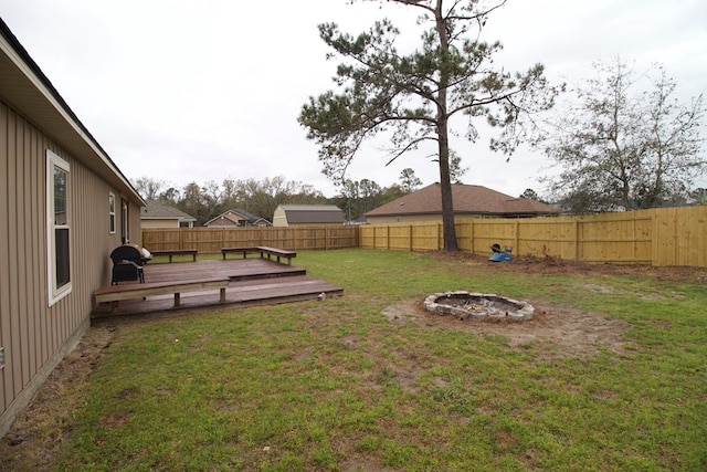 view of yard featuring an outdoor fire pit, a fenced backyard, and a wooden deck