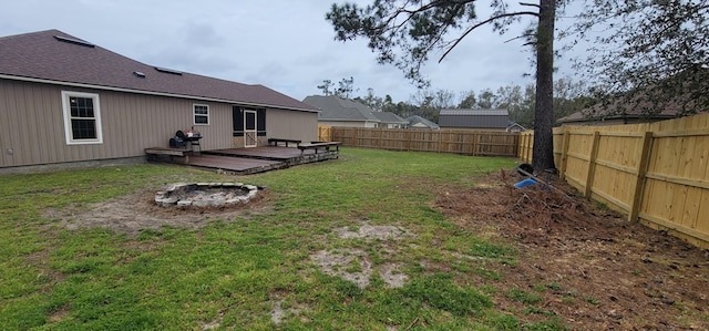 view of yard with a deck, a fire pit, and a fenced backyard