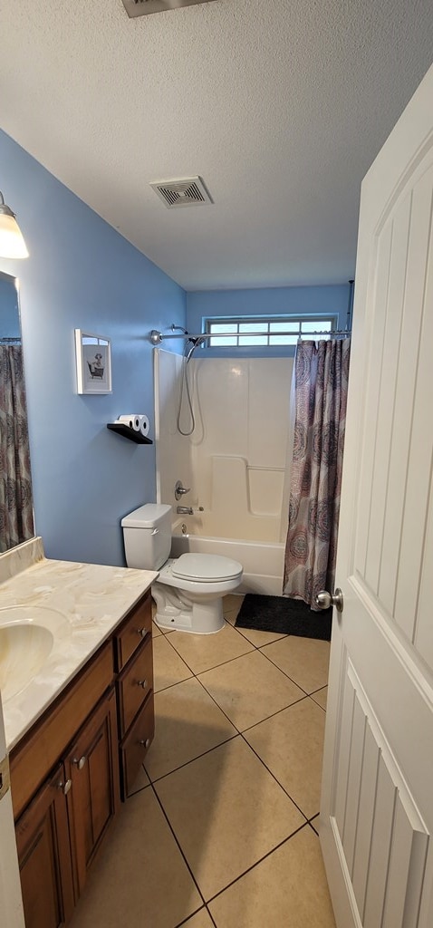 full bath featuring shower / bath combination with curtain, toilet, a textured ceiling, vanity, and tile patterned floors