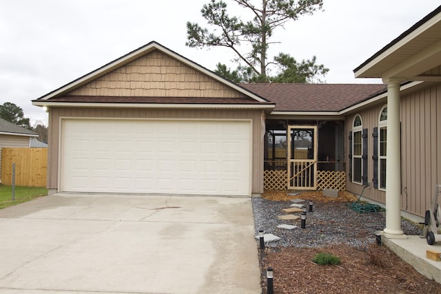 ranch-style house featuring concrete driveway, roof with shingles, fence, and an attached garage