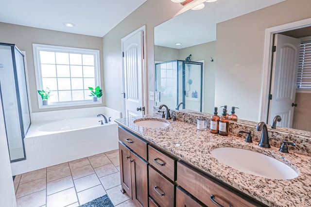 full bathroom featuring a stall shower, tile patterned floors, a bath, and a sink