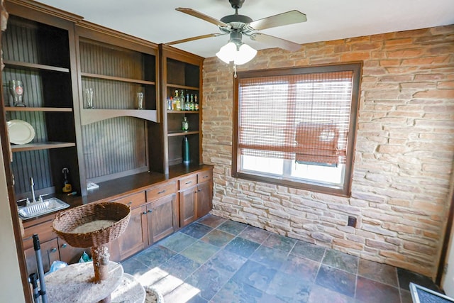 office area featuring a sink, stone finish flooring, and ceiling fan