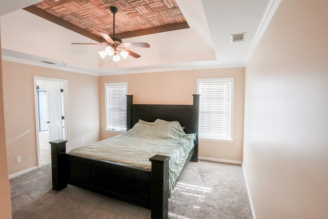bedroom with baseboards, a tray ceiling, visible vents, and carpet
