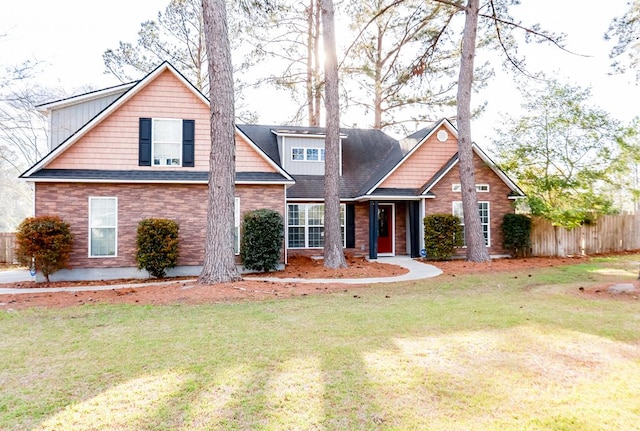 view of front of home with a front yard and fence