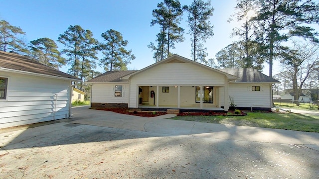 single story home featuring crawl space, a porch, a shingled roof, and driveway