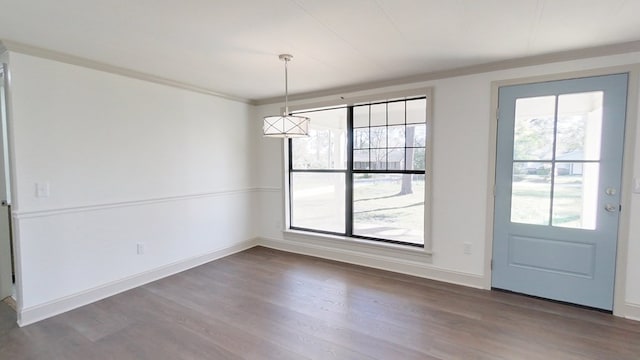 unfurnished dining area with dark wood-style floors, baseboards, and ornamental molding