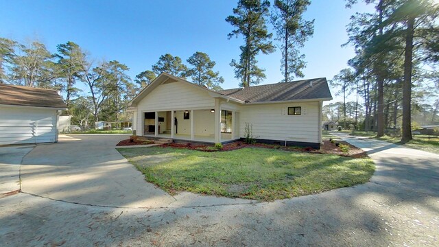 ranch-style house with a front yard, a porch, and driveway