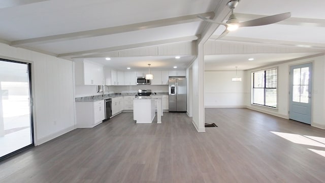 kitchen featuring white cabinetry, wood finished floors, open floor plan, and appliances with stainless steel finishes