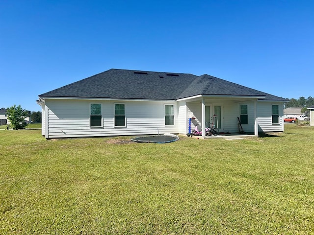 rear view of house featuring roof with shingles, a yard, a patio, and french doors
