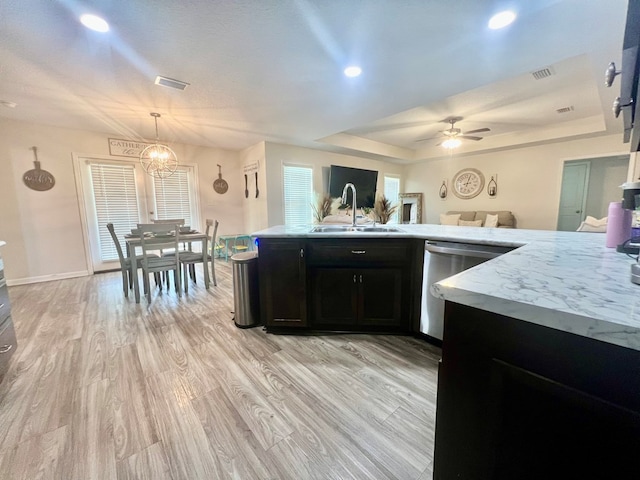 kitchen featuring dishwasher, visible vents, dark cabinetry, and a sink