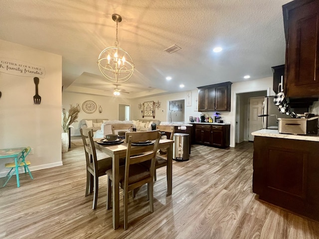 dining space with recessed lighting, visible vents, light wood-style floors, a textured ceiling, and ceiling fan with notable chandelier