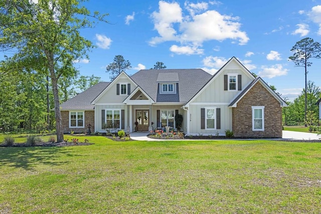 craftsman-style house with board and batten siding, roof with shingles, and a front yard