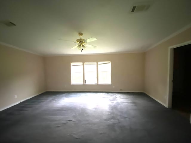 carpeted spare room featuring ceiling fan and crown molding